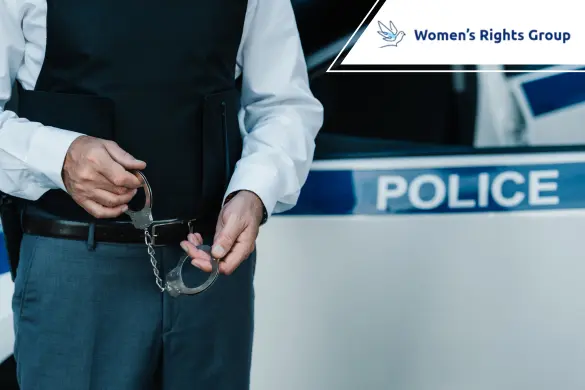 A police officer prepares to use handcuffs